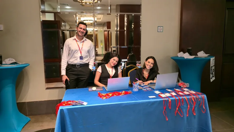 Registration opens: the welcome desk with lanyards and badges ready for arriving teams.