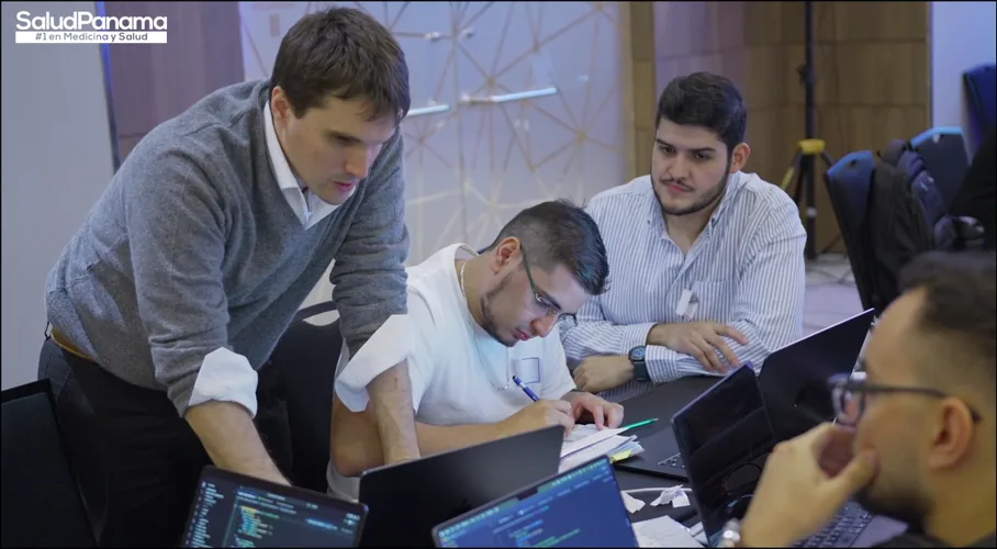 A mentor leans in to review a participant&rsquo;s notes with the team.