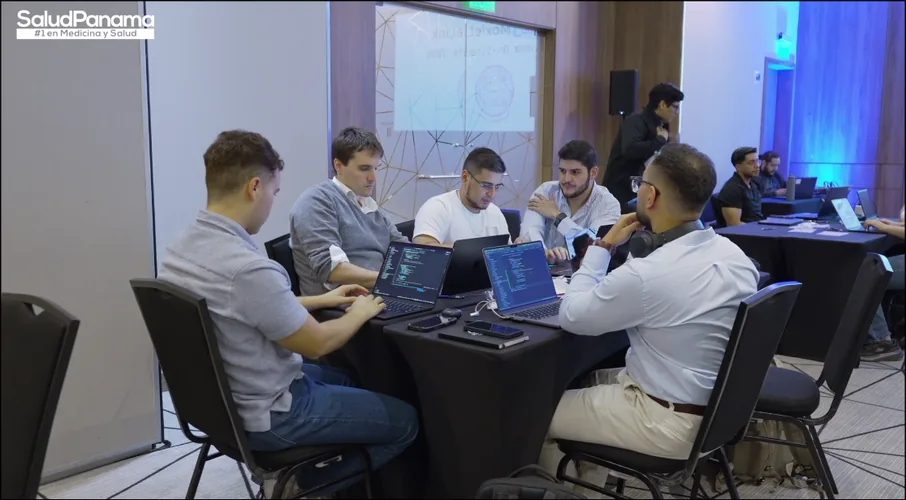 Engineering teams work together on-site at Moxiethon Panama, MoxieLink on screen behind them.