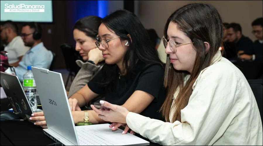 Three participants focus on their laptops during a working session.