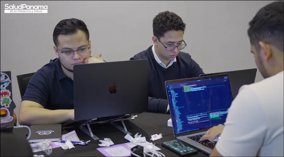 Two engineers work side by side on their laptops.
