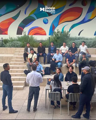 A team conversation on the steps beneath a colorful mural.