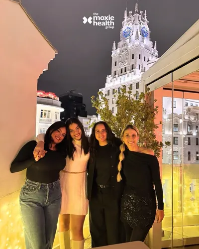 Four colleagues on a terrace overlooking Madrid at night.